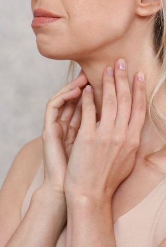 A woman with a neck issue, potentially linked to her thyroid gland.